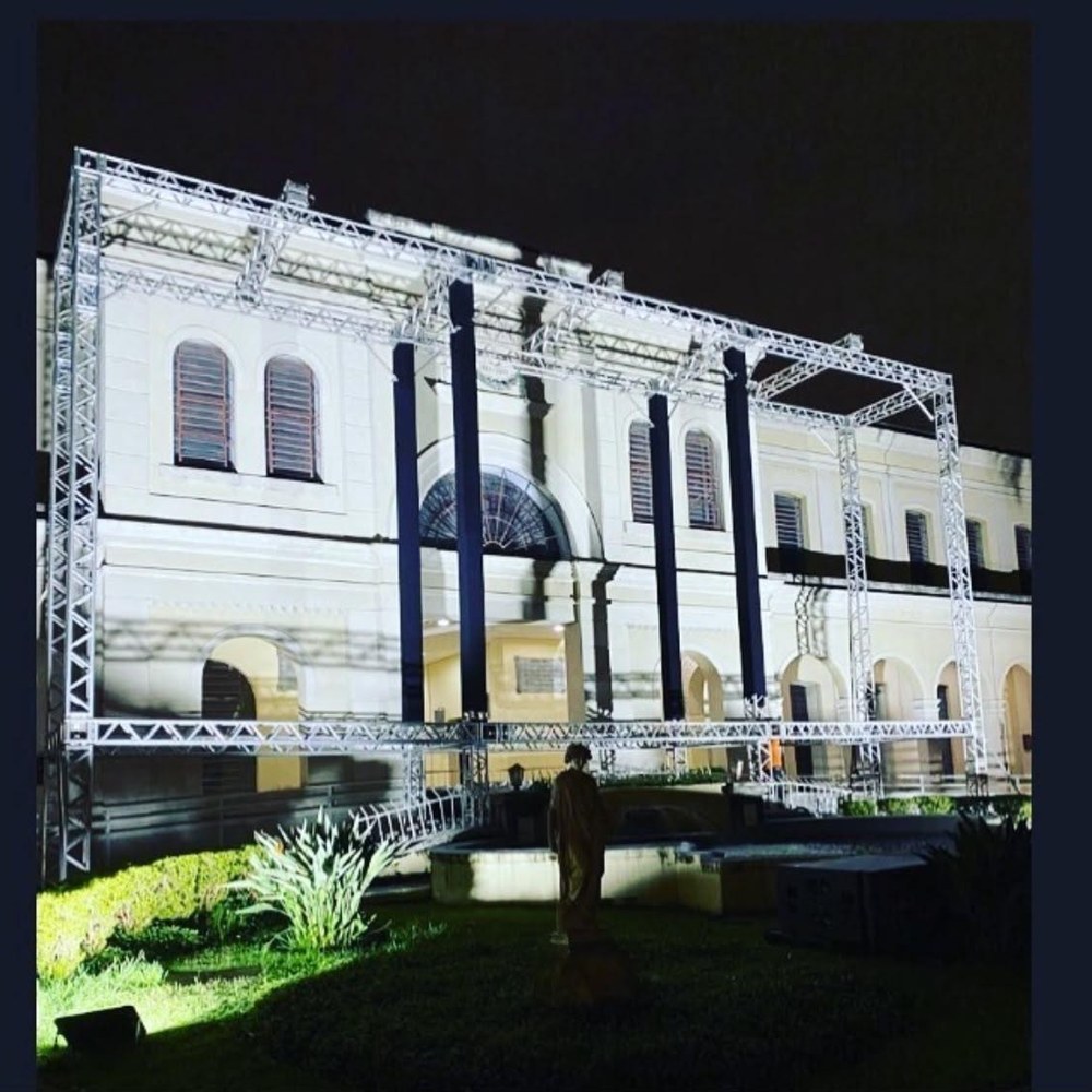 Estrutura de truss montada em fachada histórica iluminada à noite